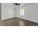 An open bedroom with wood-style floors, a window, and a ceiling fan at 5316 S Palm Dr, Tempe, AZ 85283
