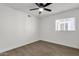 An open bedroom with wood-style floors, a window, and a ceiling fan at 5316 S Palm Dr, Tempe, AZ 85283