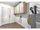 Functional laundry area with wood-look tile flooring, storage cabinets and water heater at 5316 S Palm Dr, Tempe, AZ 85283