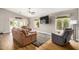Open living room with a sectional sofa, ceiling fan, and views of the backyard, perfect for relaxation and entertainment at 628 N El Dorado Dr, Gilbert, AZ 85233