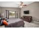 The main bedroom has a ceiling fan, neutral carpeting, large windows with a view of the pool at 628 N El Dorado Dr, Gilbert, AZ 85233