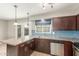 Open kitchen with dark cabinets, granite counters, stainless appliances, and backyard view at 6411 S El Camino Dr, Tempe, AZ 85283