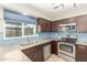 Updated kitchen features granite counters, stainless appliances, blue subway tile backsplash, and bright window at 6411 S El Camino Dr, Tempe, AZ 85283