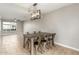 Open-concept living and dining area with modern lighting and neutral paint and tile floors at 6411 S El Camino Dr, Tempe, AZ 85283