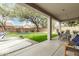Charming covered back patio with dining set overlooks a lush green lawn and provides comfortable outdoor living at 6916 E Trailridge Cir, Mesa, AZ 85207