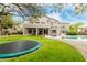A large home offers a sprawling backyard with a pool, trampoline, desert landscaping and a covered patio at 6916 E Trailridge Cir, Mesa, AZ 85207