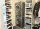 Efficient laundry area equipped with stacked washer/dryer and organized storage shelves at 6916 E Trailridge Cir, Mesa, AZ 85207
