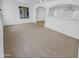 Cozy living room with neutral carpeting, arched doorways, and ample natural light, creating a comfortable space at 7334 W Comet Ave, Peoria, AZ 85345