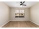 This bedroom offers neutral walls, a ceiling fan, and wood-look floors at 7839 E Osage Ave, Mesa, AZ 85212