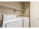 This laundry room has a washer, dryer, and shelving at 7839 E Osage Ave, Mesa, AZ 85212