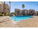 Community pool with clear blue water, surrounded by lush landscaping and comfortable lounge chairs at 8245 E Bell Rd # 133, Scottsdale, AZ 85260