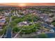 Stunning sunset aerial of a vibrant Primary-planned community with lush green spaces and beautiful homes at 9439 E Trailside Vw, Scottsdale, AZ 85255
