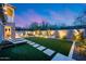 Expansive backyard with turf, pavers, barbecue, fire pit, and outdoor lounge chairs at 9439 E Trailside Vw, Scottsdale, AZ 85255