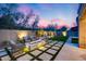 Backyard with artificial turf, stone pavers, fire pit, and comfortable outdoor seating at 9439 E Trailside Vw, Scottsdale, AZ 85255