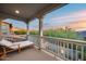 Relaxing balcony with a daybed offers serene views of the mountains and lush greenery at 9439 E Trailside Vw, Scottsdale, AZ 85255