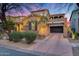 Charming brick home with a two-car garage and desert landscaping under a vibrant sunset sky at 9439 E Trailside Vw, Scottsdale, AZ 85255