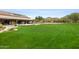 Well-manicured lawn with lush green grass, next to a community building with mountain views at 9439 E Trailside Vw, Scottsdale, AZ 85255