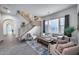 Bright living room features tile flooring, large windows, and a staircase leading to the upper level at 9439 E Trailside Vw, Scottsdale, AZ 85255