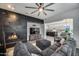 View of a living room with a fireplace, ceiling fan, comfortable seating, and open access to the kitchen at 9439 E Trailside Vw, Scottsdale, AZ 85255