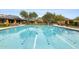 Inviting community pool featuring lane lines, bright orange umbrellas and comfortable lounge chairs at 9439 E Trailside Vw, Scottsdale, AZ 85255