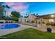 Expansive backyard with a sparkling pool, patio, lush grass, and desert landscaping, perfect for outdoor enjoyment at 9760 E San Salvador Dr, Scottsdale, AZ 85258