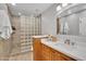 Bathroom with a unique glass block shower and a stylish wood vanity with stone countertop at 9760 E San Salvador Dr, Scottsdale, AZ 85258