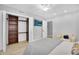 Bright bedroom with light gray walls, modern ceiling fan, TV, and closet shelving at 9760 E San Salvador Dr, Scottsdale, AZ 85258