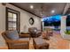 Relaxing covered patio with wicker furniture, ceiling fan, and views of the backyard and swimming pool at 9760 E San Salvador Dr, Scottsdale, AZ 85258