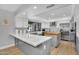 Spacious kitchen featuring island, quartz countertop, stainless steel fridge, and ample cabinet space at 9760 E San Salvador Dr, Scottsdale, AZ 85258