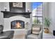 Inviting living room featuring a cozy fireplace, comfortable seating, and a view of the outdoors through large windows at 9760 E San Salvador Dr, Scottsdale, AZ 85258