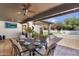 Covered patio with outdoor dining set and comfortable seating, plus a view of the landscaped backyard at 9760 E San Salvador Dr, Scottsdale, AZ 85258