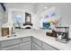Close-up of a wet bar featuring a stainless steel sink and countertop with a view of the living spaces at 9760 E San Salvador Dr, Scottsdale, AZ 85258