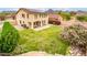 A large backyard with green grass, desert landscaping, and a two-story home at 10219 E Le Marche Dr, Scottsdale, AZ 85255