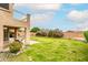 Spacious backyard featuring lush green grass, desert landscaping, and a covered patio at 10219 E Le Marche Dr, Scottsdale, AZ 85255