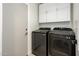 A functional laundry room with overhead cabinets and a new Samsung washer and dryer at 10219 E Le Marche Dr, Scottsdale, AZ 85255