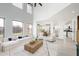 Open-concept living room with a high ceiling, large windows, neutral decor, and seamless flow to the kitchen at 10219 E Le Marche Dr, Scottsdale, AZ 85255