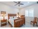 Cozy bedroom with a ceiling fan, shuttered windows, and classic wooden furniture at 10260 W Pinnacle Vista Dr, Peoria, AZ 85383