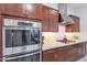 Close up of the kitchen featuring stainless steel oven, cooktop, and custom cabinets at 10260 W Pinnacle Vista Dr, Peoria, AZ 85383