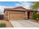 Charming single-story home showcasing a tan exterior, a two-car garage, and desert landscaping at 10835 W Saddlehorn Rd, Peoria, AZ 85383