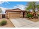 Charming single-story home showcasing a tan exterior, a two-car garage, and desert landscaping at 10835 W Saddlehorn Rd, Peoria, AZ 85383