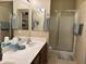 Bathroom showcasing dual sinks, a glass-enclosed shower, and a well-organized closet space at 10960 E Monte Ave # 169, Mesa, AZ 85209