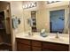 Bathroom featuring a double vanity, well-lit mirror, and an organized closet at 10960 E Monte Ave # 169, Mesa, AZ 85209