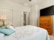 Bedroom with ceiling fan, adjacent bathroom, closet with sliding doors, and mounted TV at 10960 E Monte Ave # 169, Mesa, AZ 85209