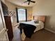 Cozy bedroom with a wood bed frame, ceiling fan, dresser, and a window with natural light at 10960 E Monte Ave # 169, Mesa, AZ 85209