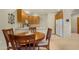 Dining area with a round table in the foreground, and kitchen with oak cabinets in the background at 10960 E Monte Ave # 169, Mesa, AZ 85209