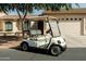 A white Yamaha golf cart sits parked on the street in front of a suburban home at 10960 E Monte Ave # 169, Mesa, AZ 85209