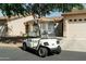 A white Yamaha golf cart sitting on the street in front of a stucco house at 10960 E Monte Ave # 169, Mesa, AZ 85209