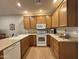 Well-equipped kitchen featuring wooden cabinets, granite countertops, and modern white appliances at 10960 E Monte Ave # 169, Mesa, AZ 85209