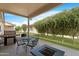 Charming covered patio with a dining set and fire pit, surrounded by well-maintained landscaping and lush trees at 10960 E Monte Ave # 169, Mesa, AZ 85209