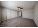 Spacious bedroom featuring plush carpeting, neutral wall color, ceiling fan, and a large closet at 11275 N 99Th Ave # 170, Peoria, AZ 85345